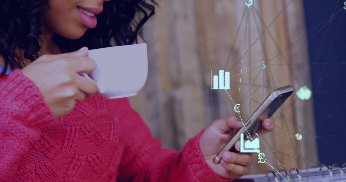 Woman holding coffee mug and tapping smartphone at wooden table, displaying animated finance icons