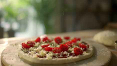 fresh homemade pizza with cherry tomatoes on kitchen table