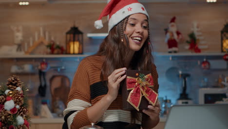 persona caucásica mostrando un regalo envuelto en una llamada de video