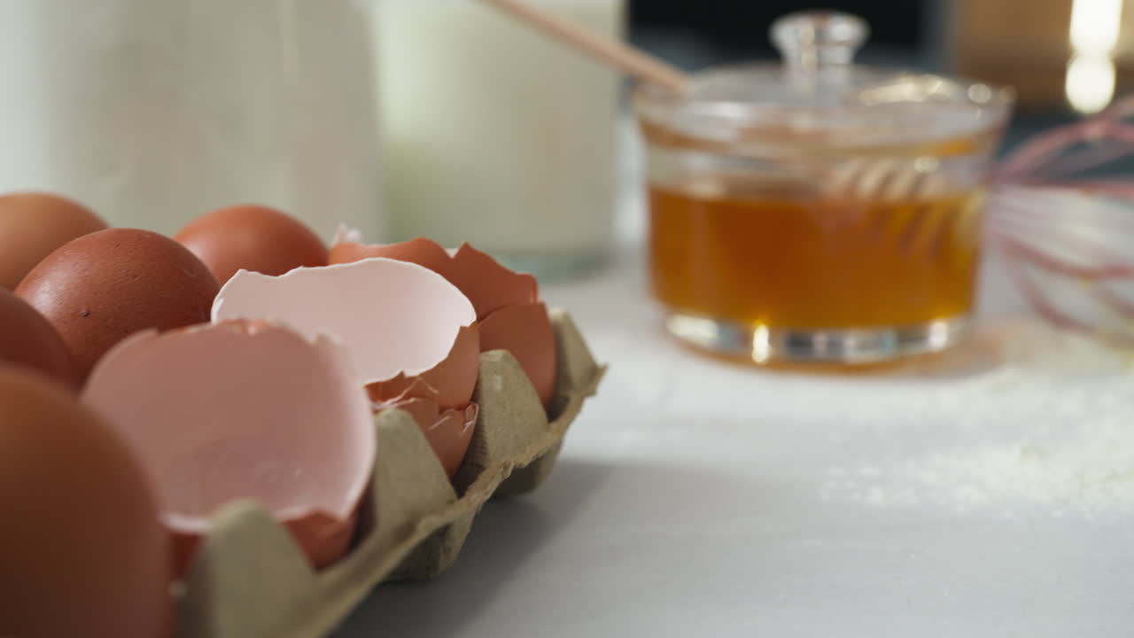 Person taking an egg from the egg cup on the kitchen table to cook