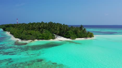 Idyllische-Tropische-Insel-Mit-Dichtem-Palmenwald,-Umspült-Von-Einer-Ruhigen-Türkisfarbenen-Lagune-Voller-Korallen,-Hoher-Kommunikationsantenne-Im-Zentrum-Der-Karibischen-Insel