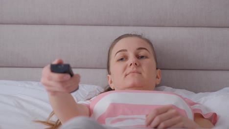 charming smiling woman in a shirt and trousers lies on a bed in a bright bedroom charming smiling woman in a shirt and trousers lies on a bed in a bright bedroom