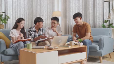 asian teen group studying at home. group with books looking at a laptop arguing and trying to blame each other