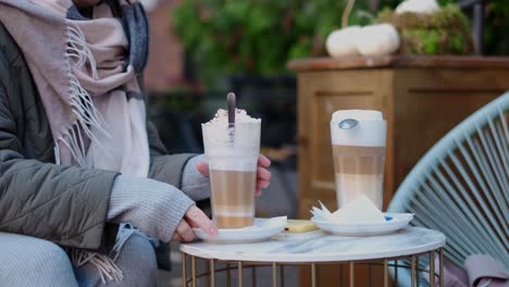 woman enjoying lattes in an outdoor cafe during autumn
