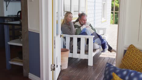 Glückliches-Kaukasisches-Reifes-Paar,-Das-Auf-Der-Terrasse-Am-Meer-Sitzt