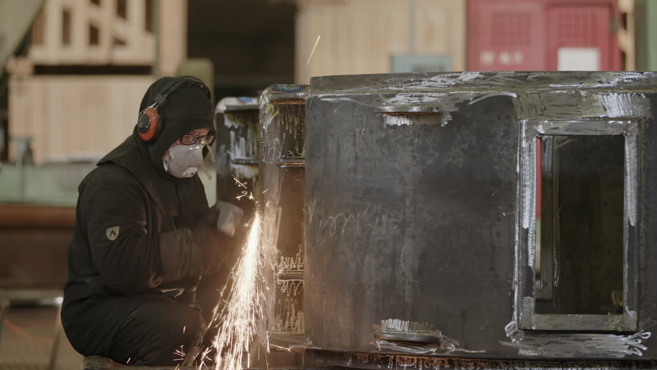 trabajador metálico moliendo piezas metálicas en una fábrica