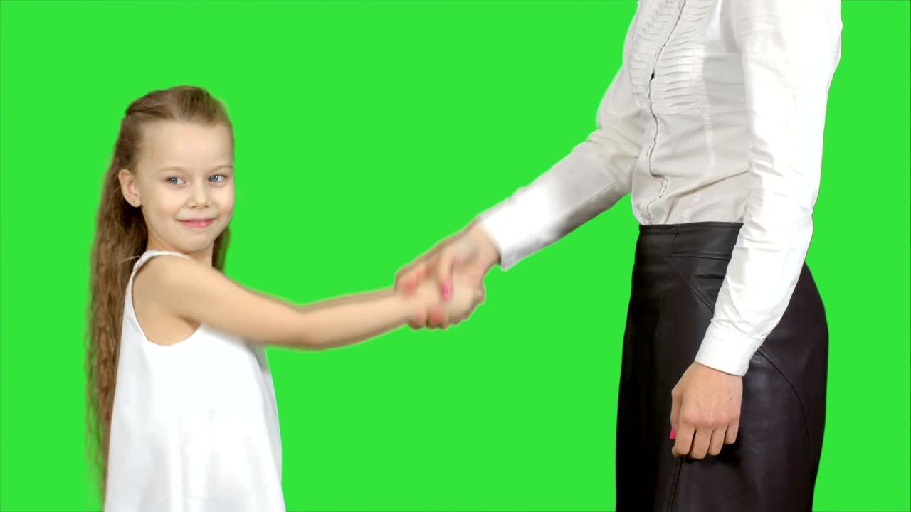 Figlia e madre si stringono la mano su uno schermo verde, Chroma Key.