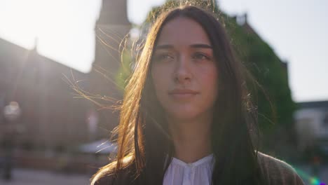 Primer-Plano-De-La-Cara-De-Una-Mujer-Iluminada-Con-Luz-Dorada-Sobre-El-Cabello-Desordenado-Azotado-Por-El-Viento