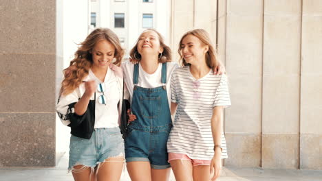 three happy friends walking in the city