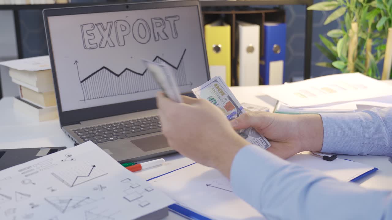 Successful businessman looking at earnings charts and counting money.