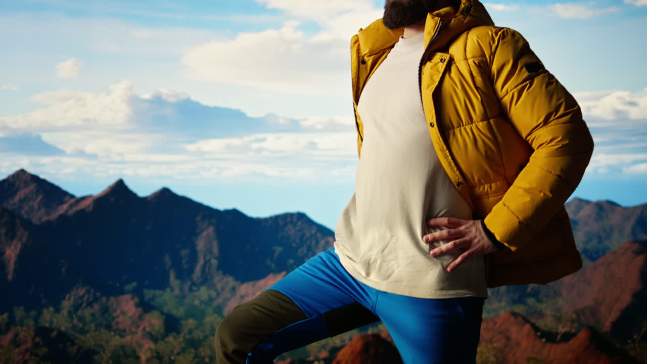 단호한 등반자는 하늘과 바위 산꼭대기를 쳐다본다.