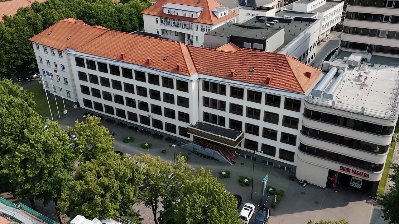 La facciata del pronto soccorso della Respublikinė Klaipėdos ligoninė è vista dall'alto con un'ambulanza parcheggiata all'ingresso e pedoni nelle vicinanze.
