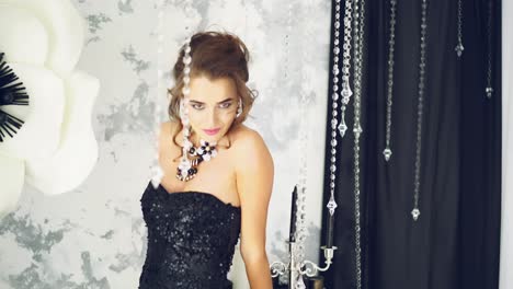 jonge vrouw die in een luxe kamer staat. mooie jonge vrouw die in het lichte luxe kamerinterieur staat.