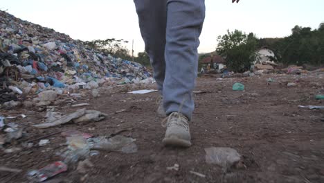person walking through a landfill