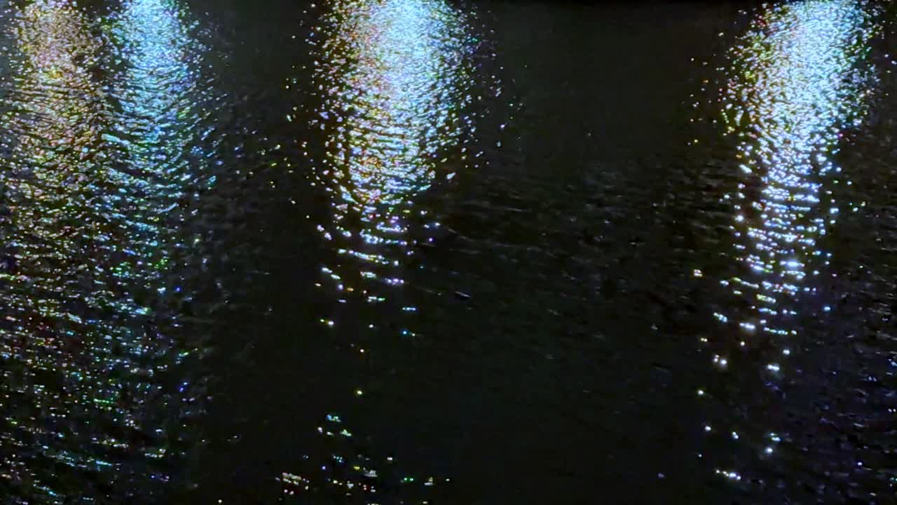reflejos brillantes en el agua por la noche, con patrones de luz coloridos