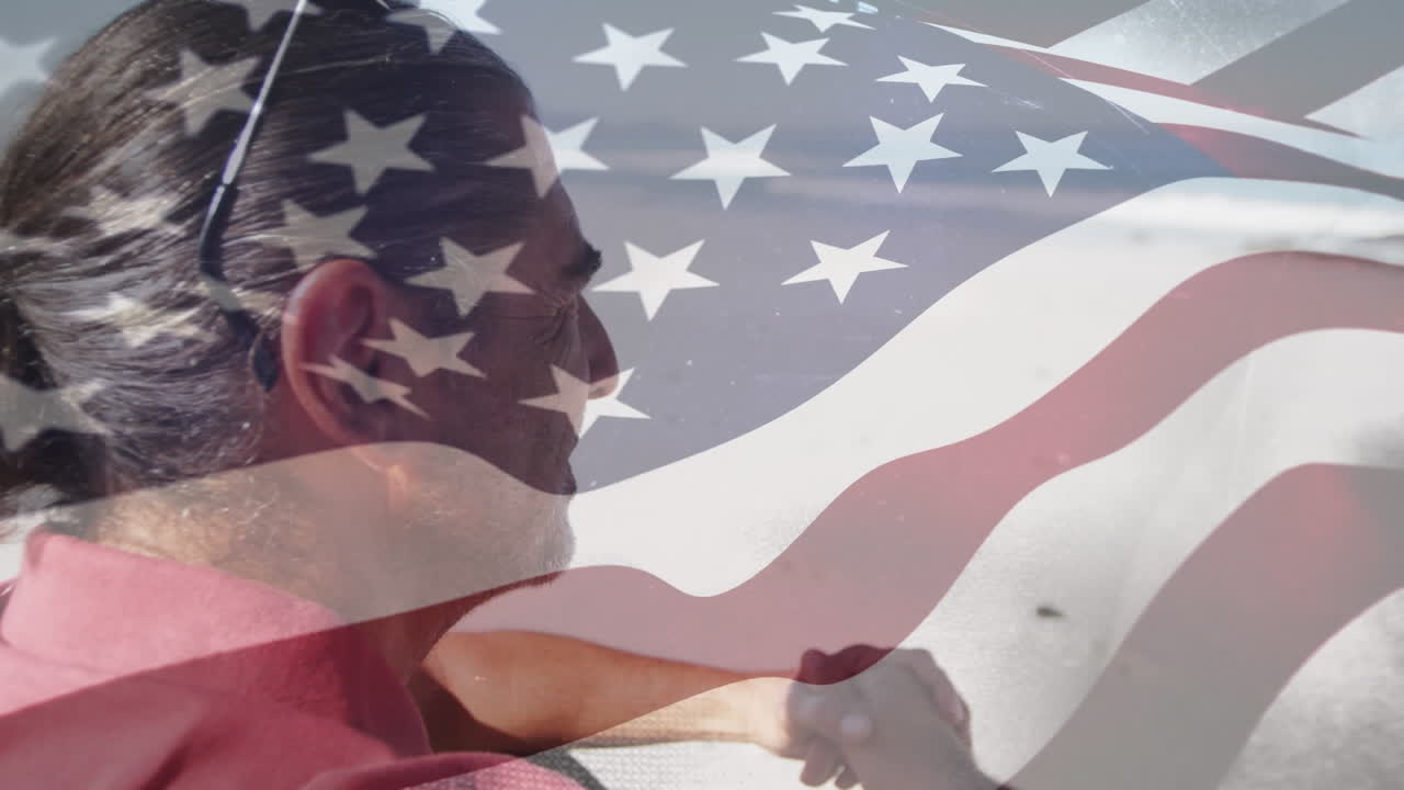 animación de un anciano biracial en la playa sobre la bandera de los estados unidos