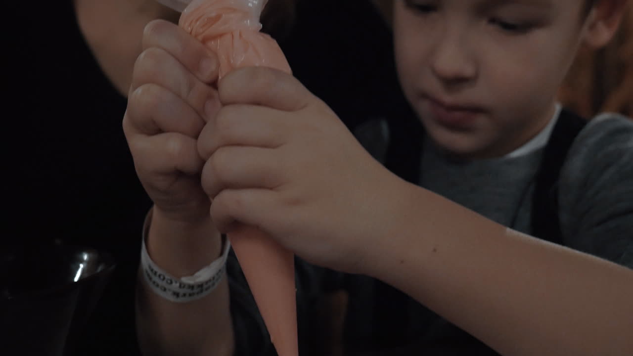 madre y niño decorando galleta de pan de jengibre con helado