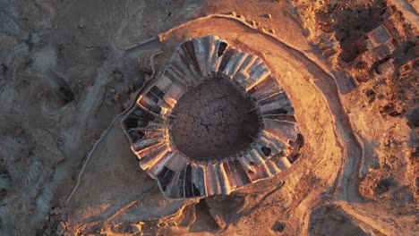 aerial shot of ancient ruins in the tunisian desert. shows unique circular structure and surrounding landscape.