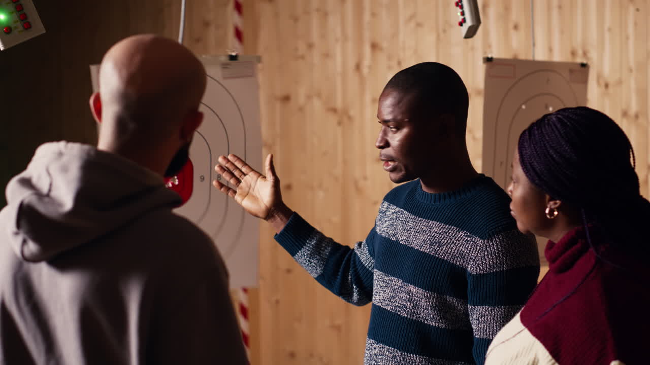 Shooting gallery instructor explaining bullseye scoring system to customers