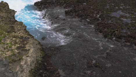 Olas-Rompiendo-En-El-Arrecife-Rocoso-A-Cámara-Lenta,-Creando-Un-Hermoso-Patrón-De-Espuma-Durante-El-Día