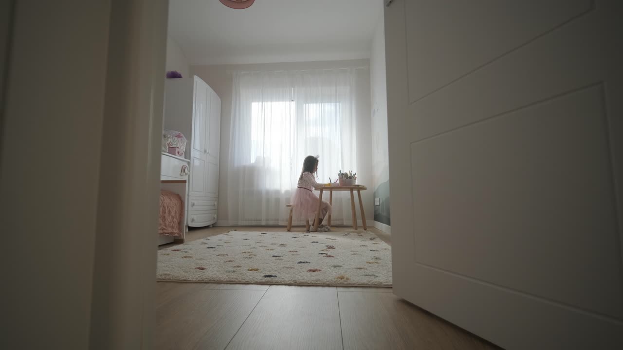 joven sentada en una mesa, dibujando con lápices de colores. ideal para temas de creatividad, desarrollo infantil, aprendizaje y actividades artísticas en un ambiente interior acogedor.