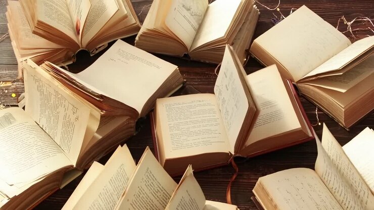 Video dall'alto di libri aperti su un tavolo di legno, con pagine che si voltano, creando una scena dinamica