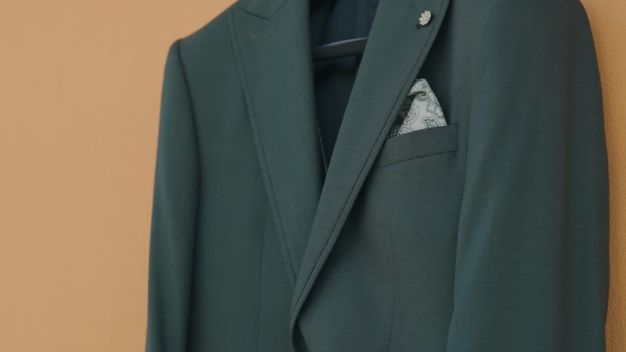 패턴 포켓 스퀘어가 있는 깔끔하게 걸린 어두운 신랑 정장