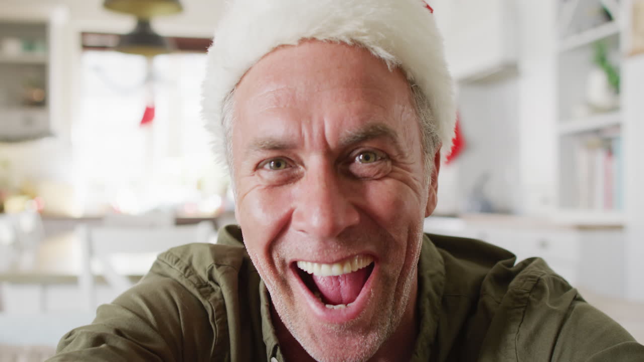 Uomo caucasico felice con il cappello da Babbo Natale, in videochiamata.