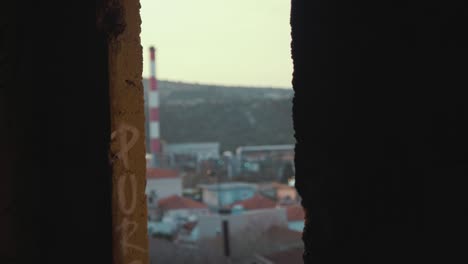 derelict building window view of factory chimneys