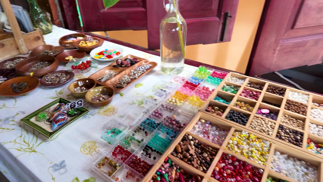 High angle shot of colorful beads and wooden bowls at a Thai handicraft market.