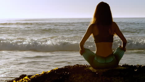 Mujer-En-Forma-Realizando-Yoga-En-La-Playa-4k