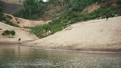 multiple local laos children near the mekong river running and playing