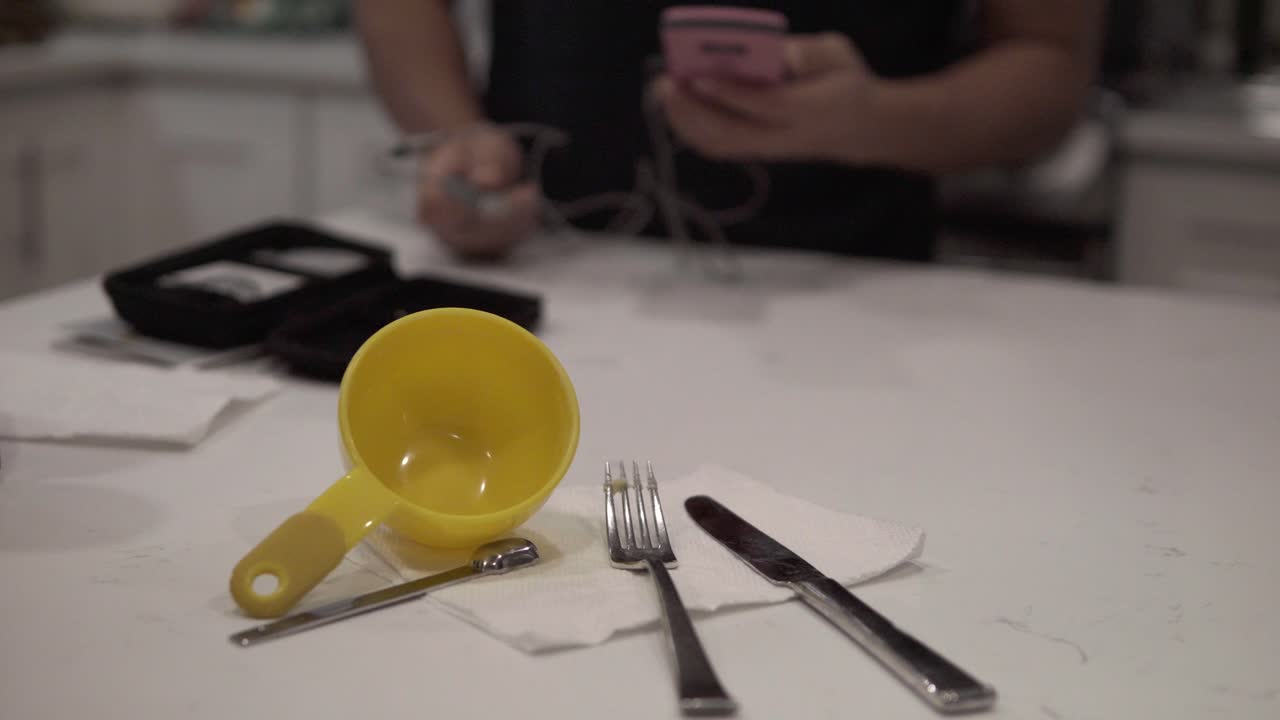 un hombre toma un termómetro de caramelo e intenta aprender a usarlo mientras hornea