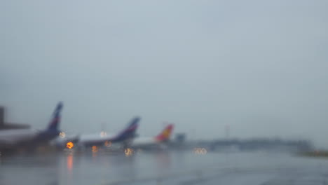 aviones en la terminal sentados en una vía de rodaje húmeda