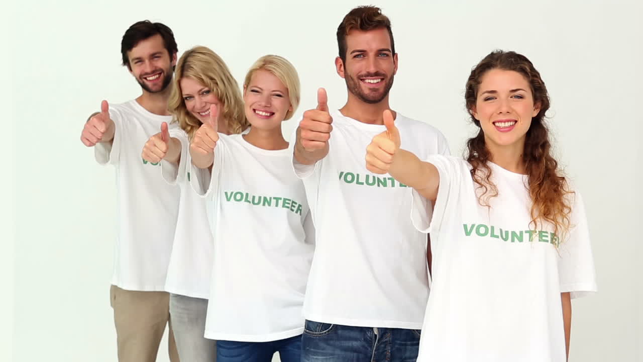 Team of volunteers giving thumbs up to camera