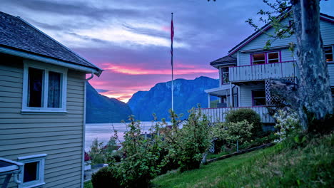 Toma-De-Lapso-De-Tiempo-De-Ondear-La-Bandera-Noruega-Frente-Al-Fiordo-Y-Las-Montañas-Al-Atardecer