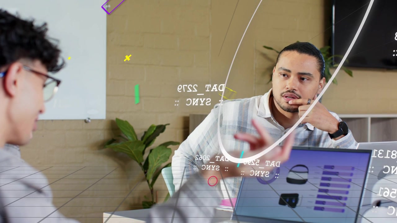 Speaker gesturing at laptop, initiating product review while animated labels appearing over desk