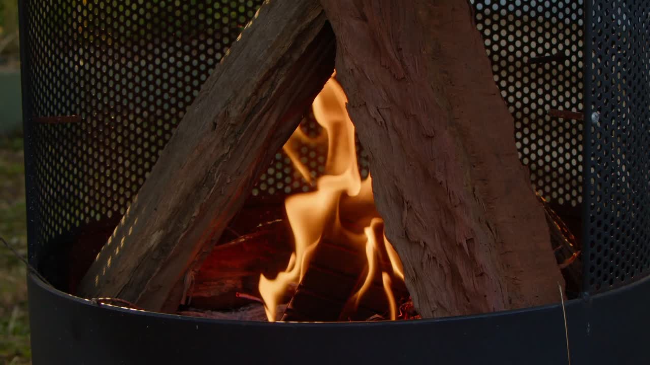 A fire starts to burn the wood logs in a outdoor fireplace