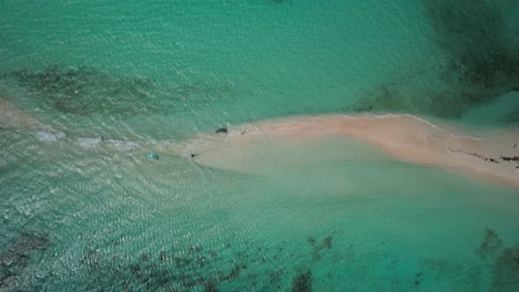 A-sandbar-stretching-through-clear-turquoise-waters,-forming-a-picturesque-landscape,-aerial-view