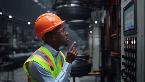 Man-worker-tapping-screen-modern-metal-construction-at-huge-industrial-factory.