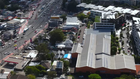 Toma-Aérea-De-Un-Suburbio-Ocupado-En-Australia-Por-Un-Puente-Con-Tráfico-Pesado-En-Las-Carreteras-Con-Automóviles-Y-Negocios