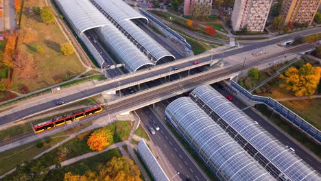 aerial of electric tram crossing through a bridge, trasa torunska motorway highway with soundproof glass panels roof, road intersection, warsaw city traffic