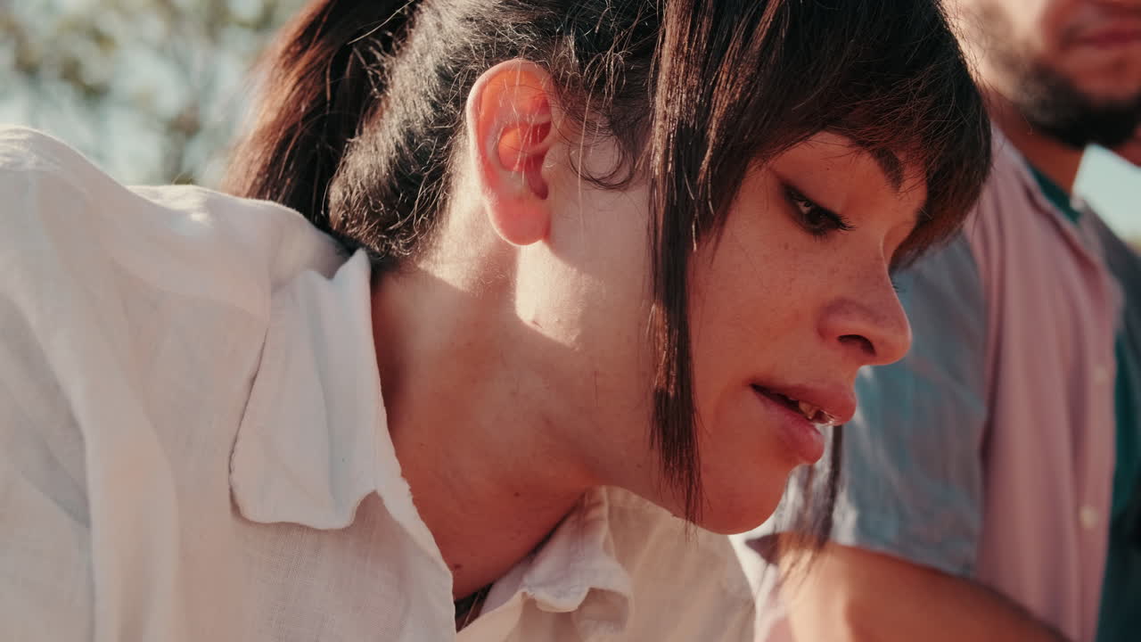 Friends Enjoying a Picnic in Golden Sunlight, focus on the young girl