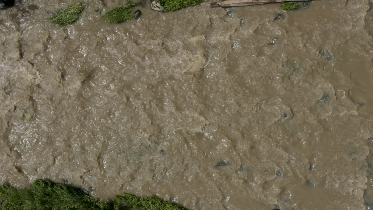 vista aérea de arriba hacia abajo en una orientación lateral de un río fangoso keravanjoki en finlandia