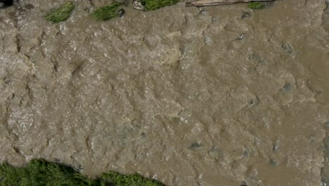 top down aerial view in a sideways orientation of a muddy keravanjoki river in finland