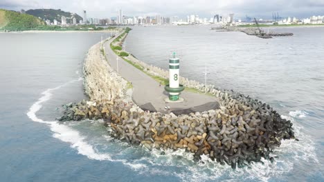 aerial cinematic view circling around the lighthouse of farol do molhe da barra de itajaí, santa catarina, brazil