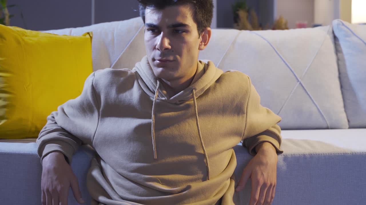 En bekymret ung mand, der dækker sit ansigt med en følelse af fortrydelse
