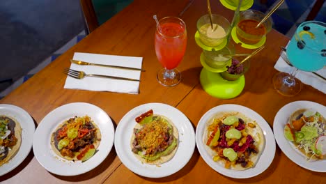 mexican tacos in restaurant table with cocktails and salsas top slider shot