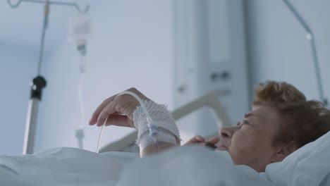 sick 80-year-old woman lying in hospital bed