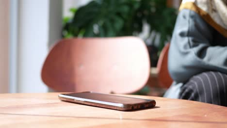 a cell phone sits on a wooden table